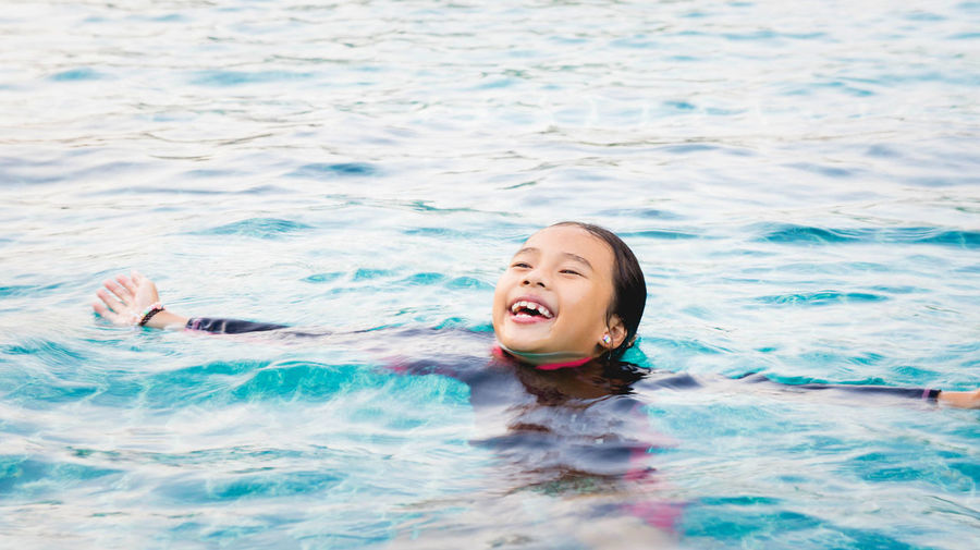 High angle view of smiling girl swimming in sea