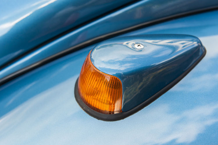 Left turn signal of a metallic blue german classic car from the 60s and 70s.