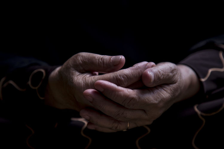 Cropped image of person with hands clasped