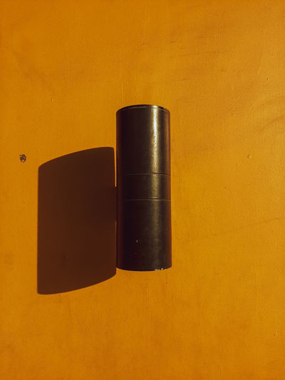 Close-up of metal object against orange background