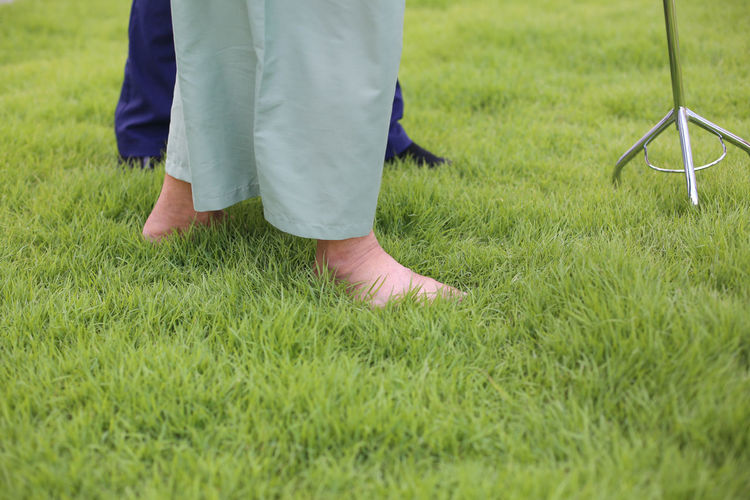 Low section of man standing on grassy field