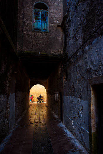 Man with bicycle in corridor of old building
