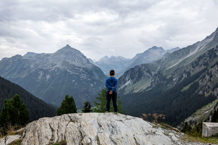 Rear view full length of boy standing against swiss alps