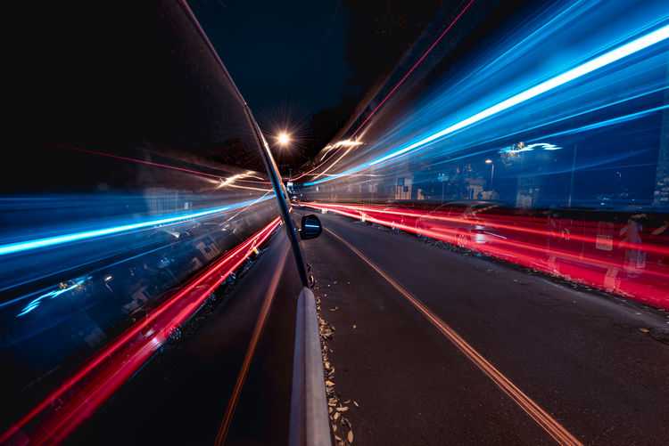 Blurred motion of light trails on road at night. electric vehicle, sustainable transportation. led