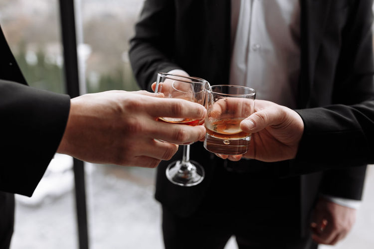 Business meeting. men hold glasses of whiskey. men's party. hand with a drink of alcohol.