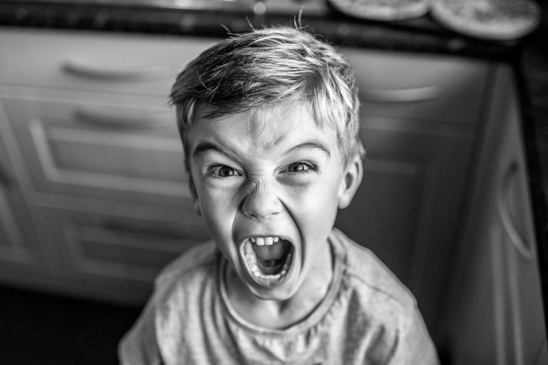 Portrait of boy screaming at home