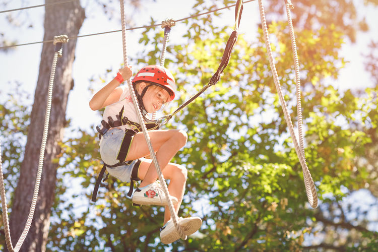 Happy girl hanging from tree