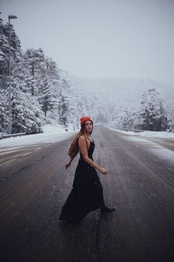 Full length of woman on road against sky during winter