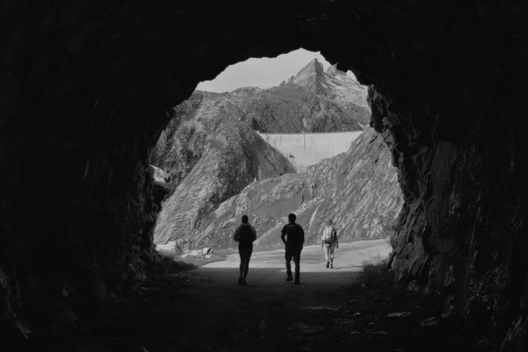 Rear view of people walking on mountain road