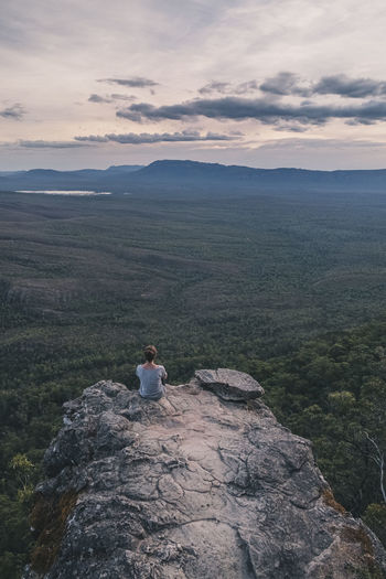 Young woman sits at the balconies admiring the vast landscape of grampians national park, victoria, australia