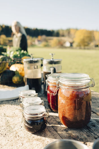 Preserves in airtight jars and french press displayed for sale on table at farmer's market
