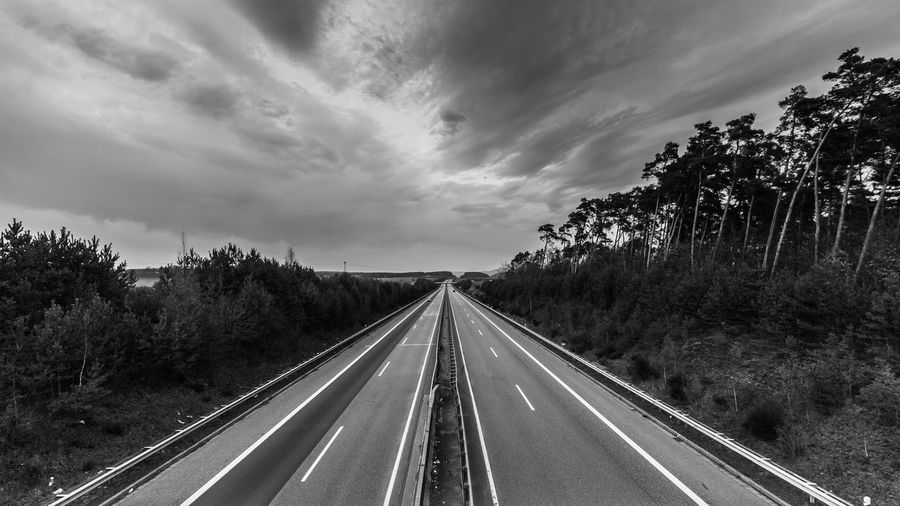 Road amidst trees against sky