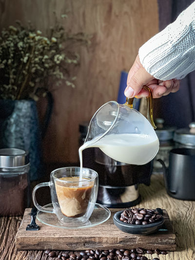 Pouring milk into a hot coffee for cafe latte