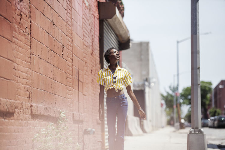 Thoughtful young woman standing on sidewalk