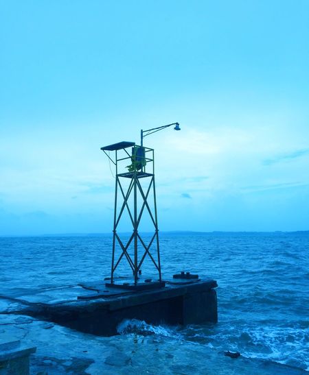 Lifeguard hut on sea against blue sky