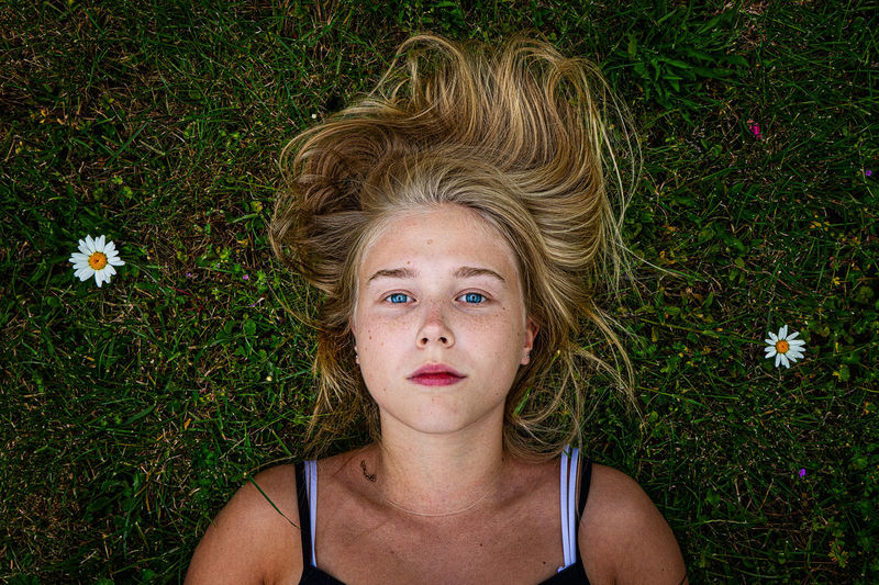 Portrait of teenage girl lying on grassy field