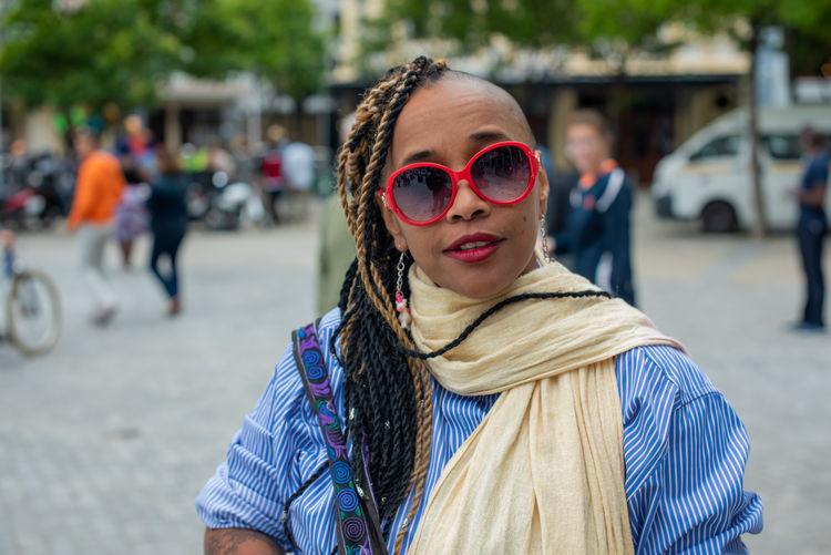 Portrait of woman with sunglasses on street in city