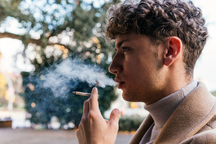 Close-up portrait of young man smoking cigarette