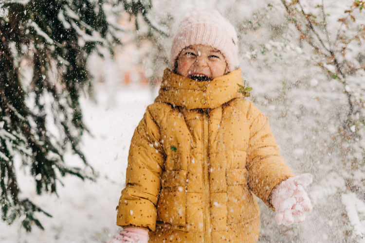 Portrait of cute girl standing outdoors in snow during winter