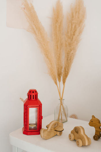 Wooden toys, dried flowers in a vase and a red lantern in the decor of the children's room