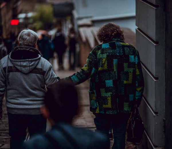 Rear view of couple holding hands while moving down on steps
