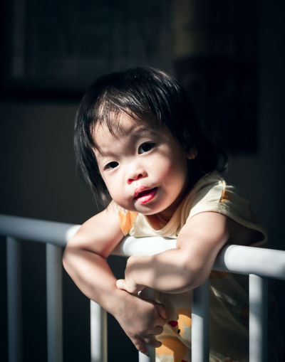 Portrait of cute baby girl in crib