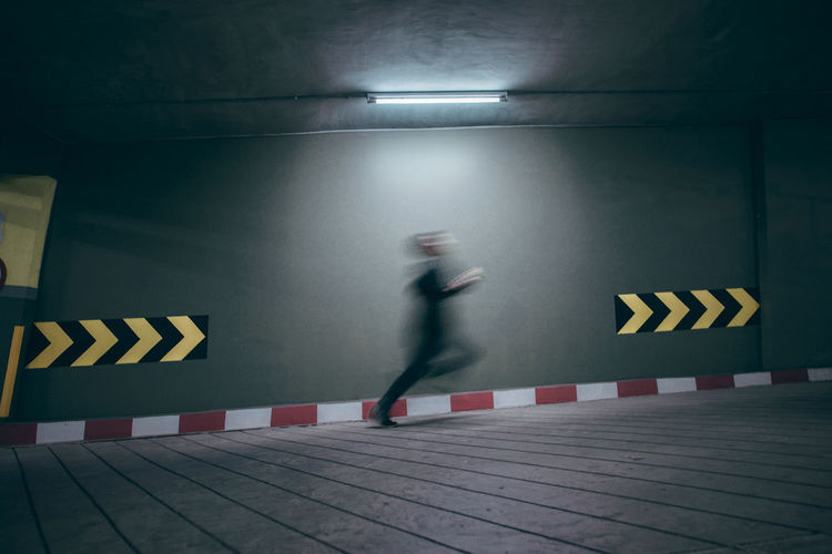 Blurred motion of man running at parking lot