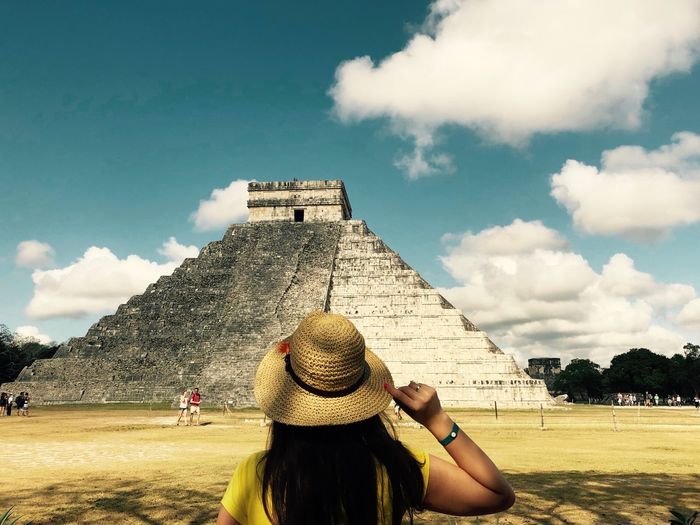 Rear view of woman looking at historic pyramid against sky