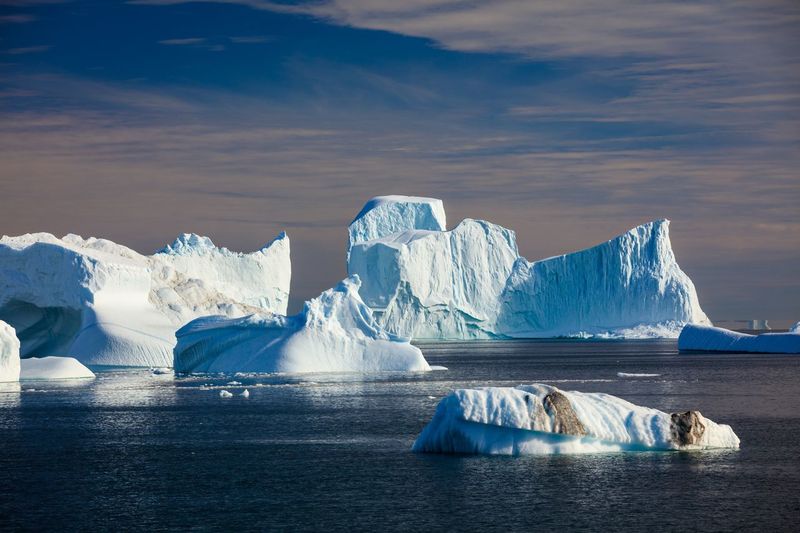 Icebergs on sea against sky
