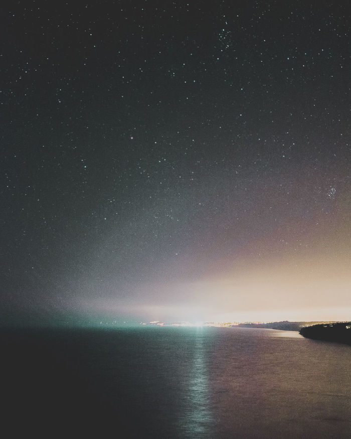 SCENIC VIEW OF SEA AGAINST STAR FIELD