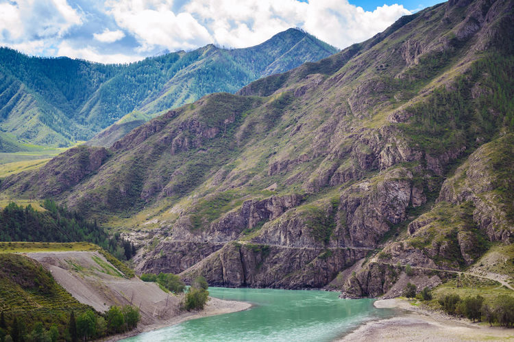 Scenic view of river amidst mountains against sky