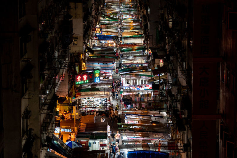 High angle view of illuminated market amidst buildings in city during night