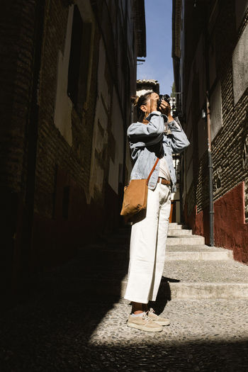 Tourist woman taking photo in granada historical quarter