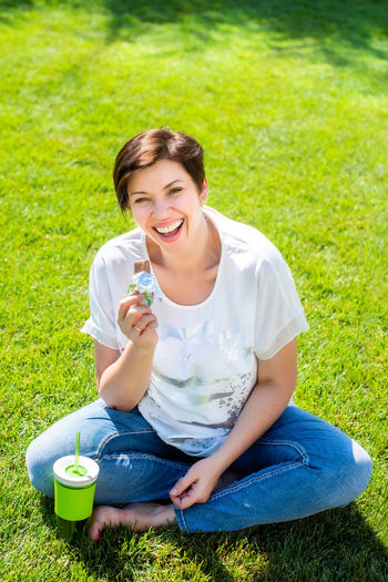 Smiling young woman sitting on field