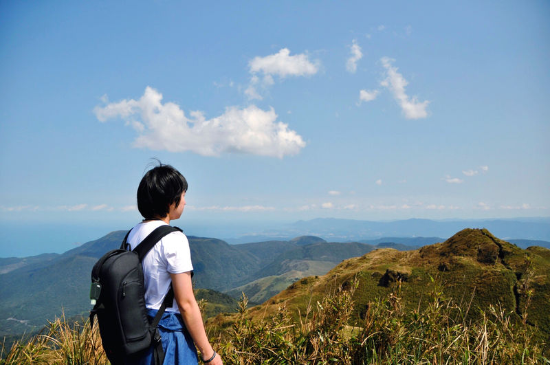 One person standing on the peak enjoy valley view. rear view of man standing on mountain against sky