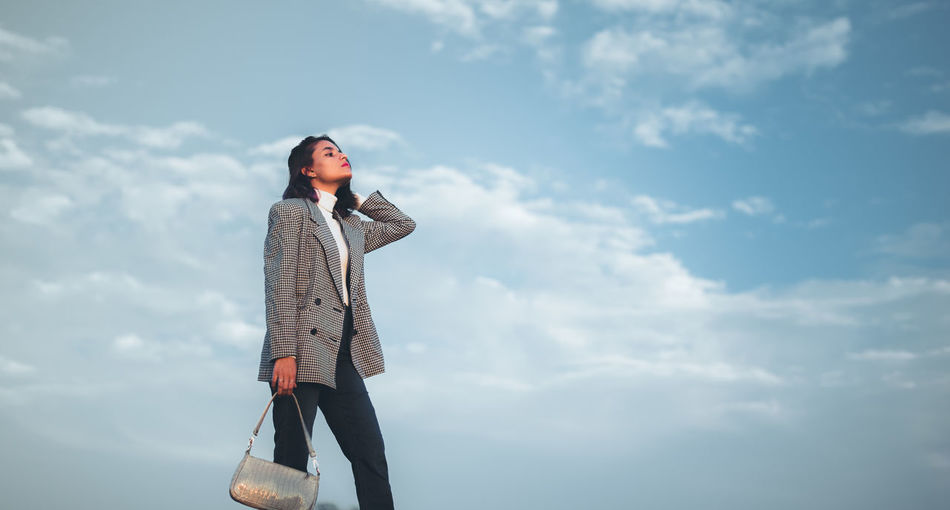 Portrait of woman standing against sky