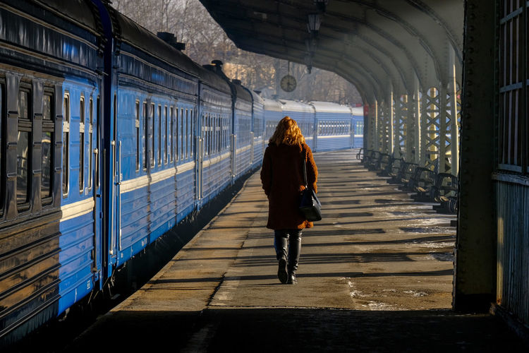 Rear view of woman walking at railroad station platform