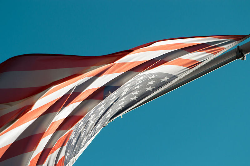 Close-up of american flag against clear blue sky