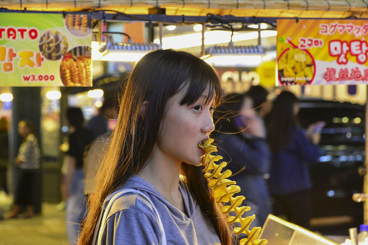 Woman eating street food at market stall