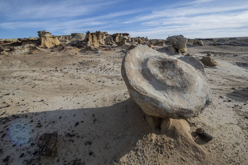 Large rock floating on small hoodoo in new mexico desert