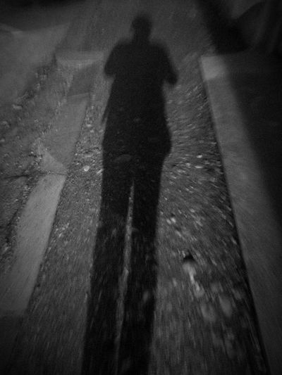 Shadow of man on asphalt
