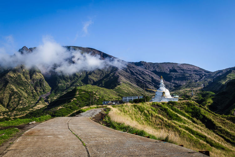 Scenic view on abandoned buddhist temple, mountains and road to mountain aso in kyushu, japan