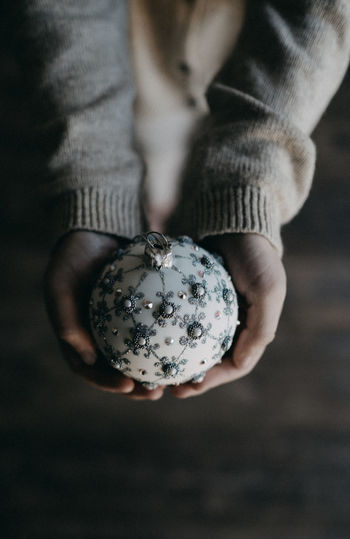 Midsection of girl holding bauble at home