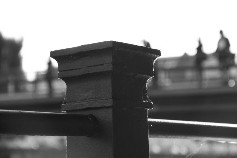 Close-up of wet railing against sky
