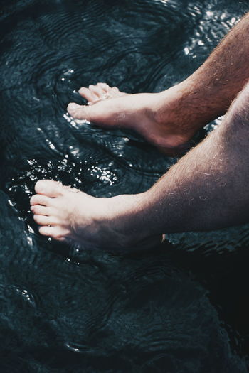 Low section of man sitting in water