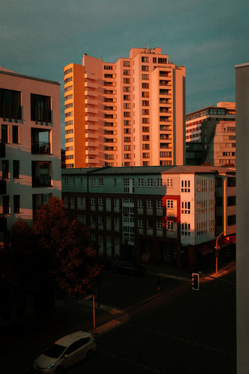 Street by buildings in city against sky