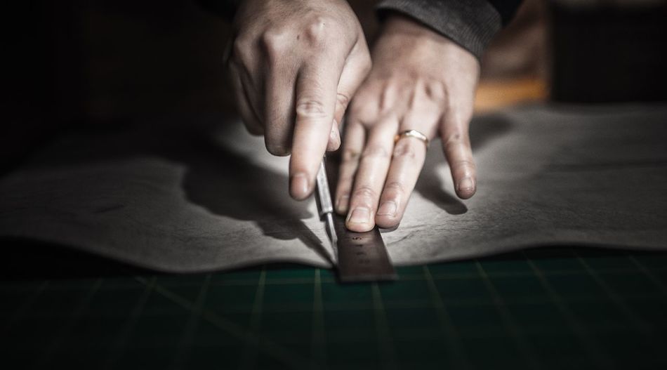 Cropped image of hands marking on paper with ruler