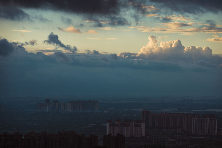 Scenic view of sea and buildings against sky during sunset