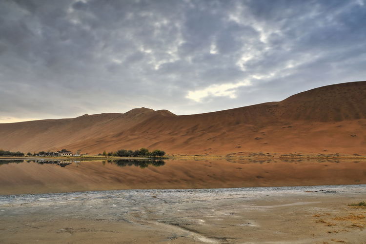 1119 sumu jaran lake and badain jaran desert temple at the foot of sand megadunes. nei mongol-china.