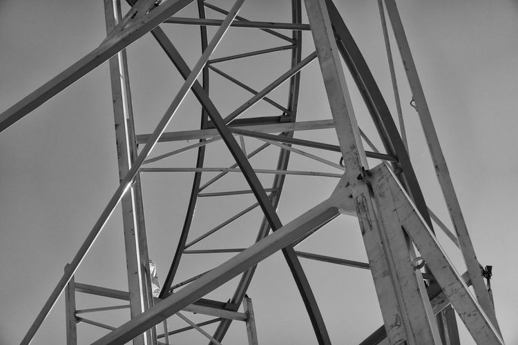 Black and white developed steel struts of a roller coaster at the fairground.